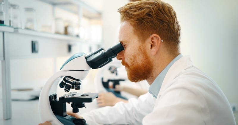 Scientist looking through a microscope