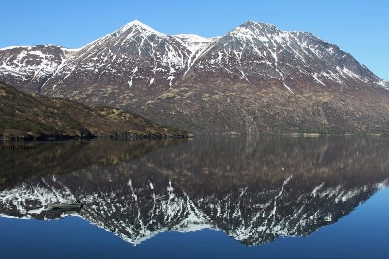 Snow dusted mountains reflecting on water, photo credit, Faith P