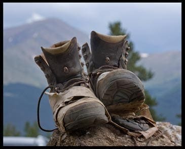 worn hiking boots with mountain in the background, photo credit: Pat Mingarelli